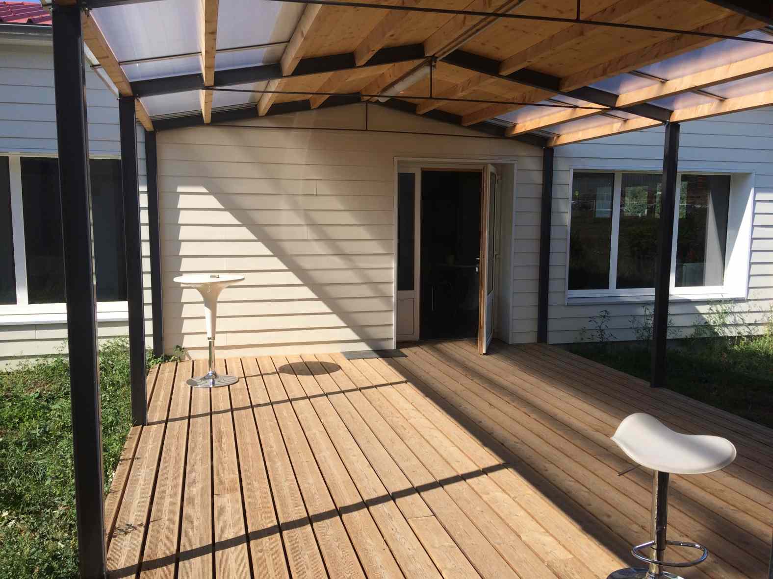 L'abri couvert relie l'ancien et le nouveau bâtiment et dessine un jardin en patio. Il est devenu le lieu de la sociabilité dans l'entreprise